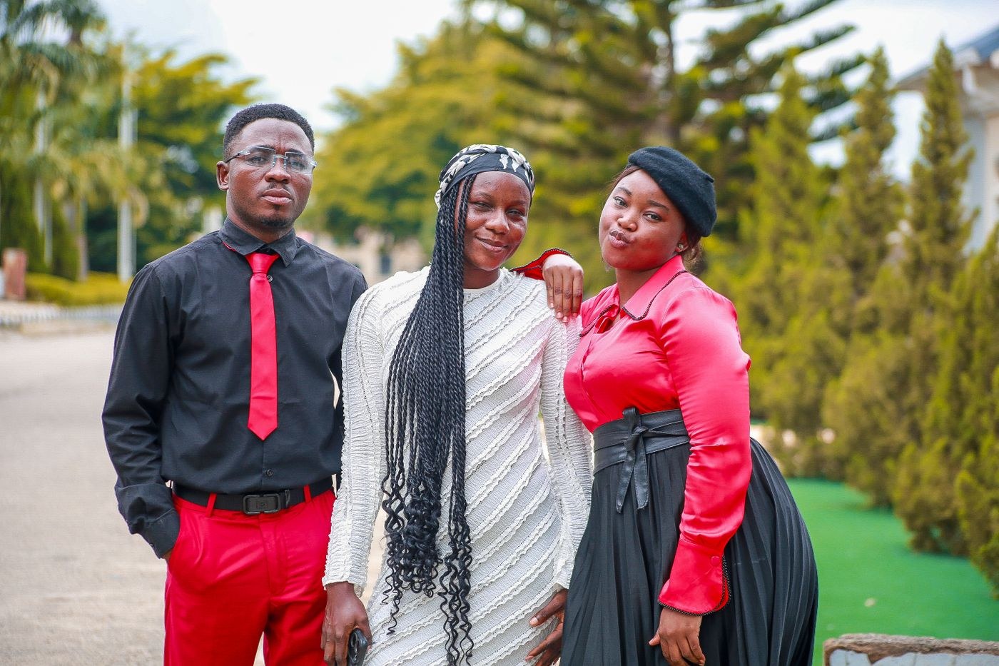 Three people posing together outdoors