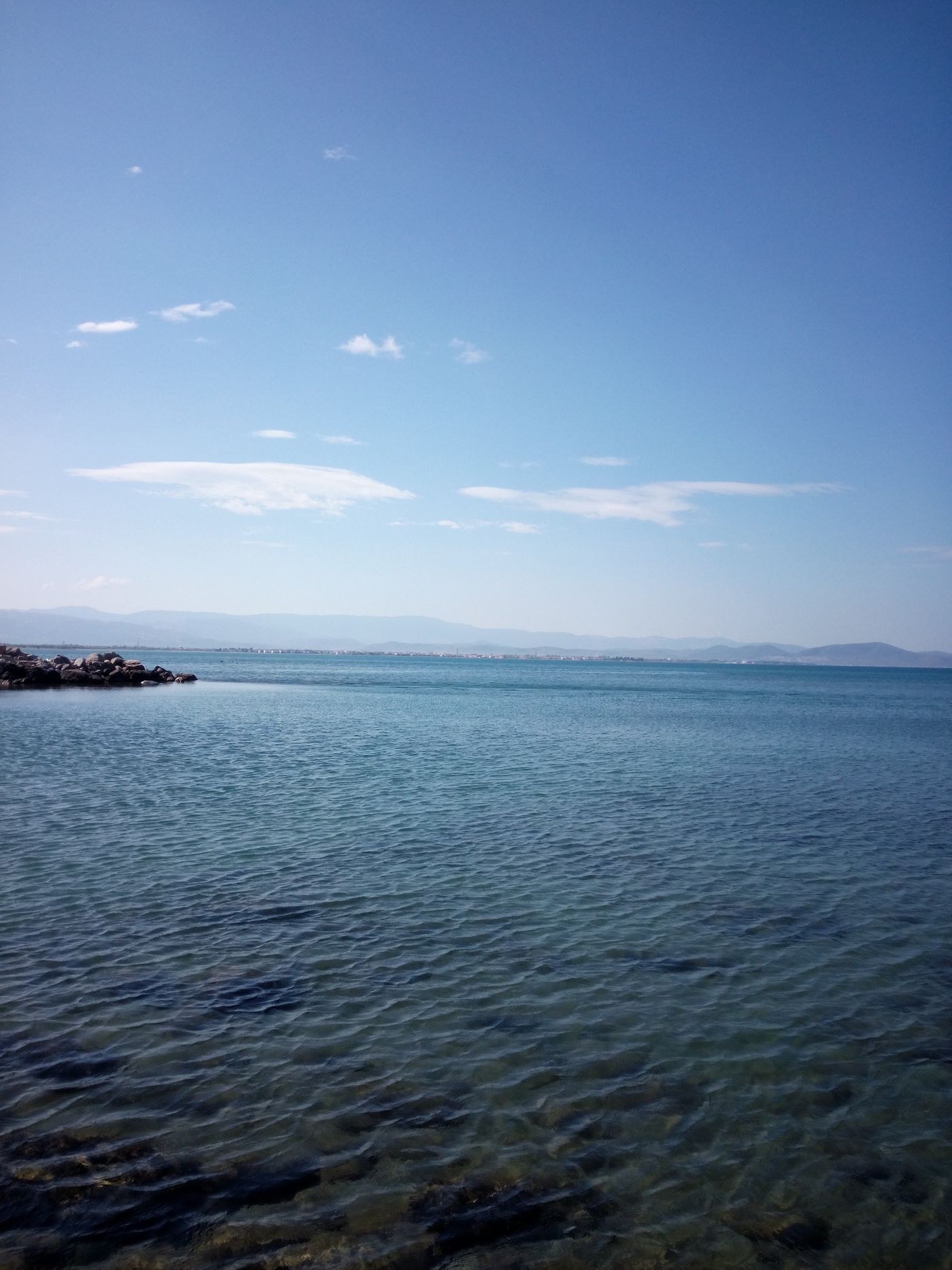 Low sea horizon beneath a broad blue sky