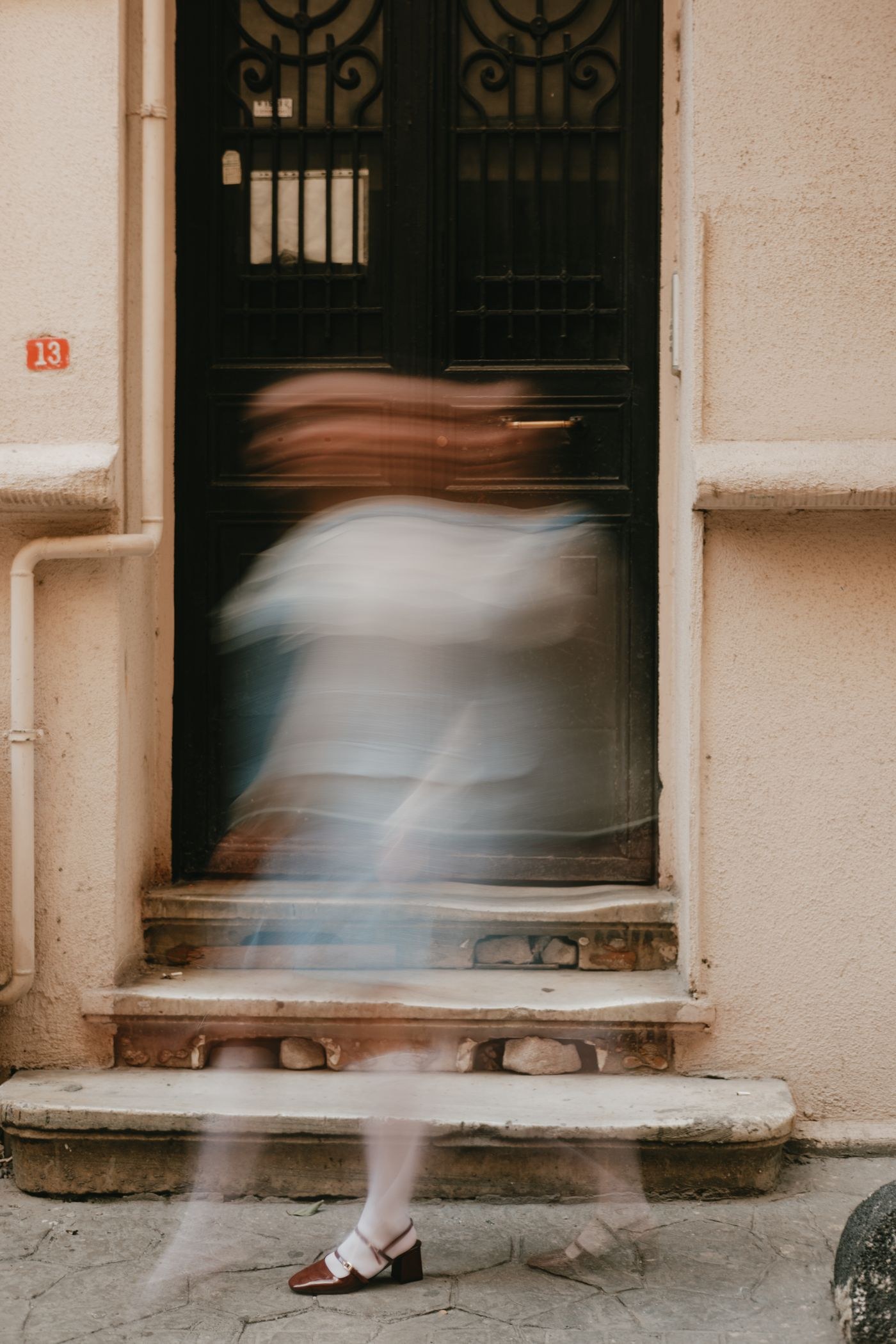 Blurred pedestrian passing an old doorway