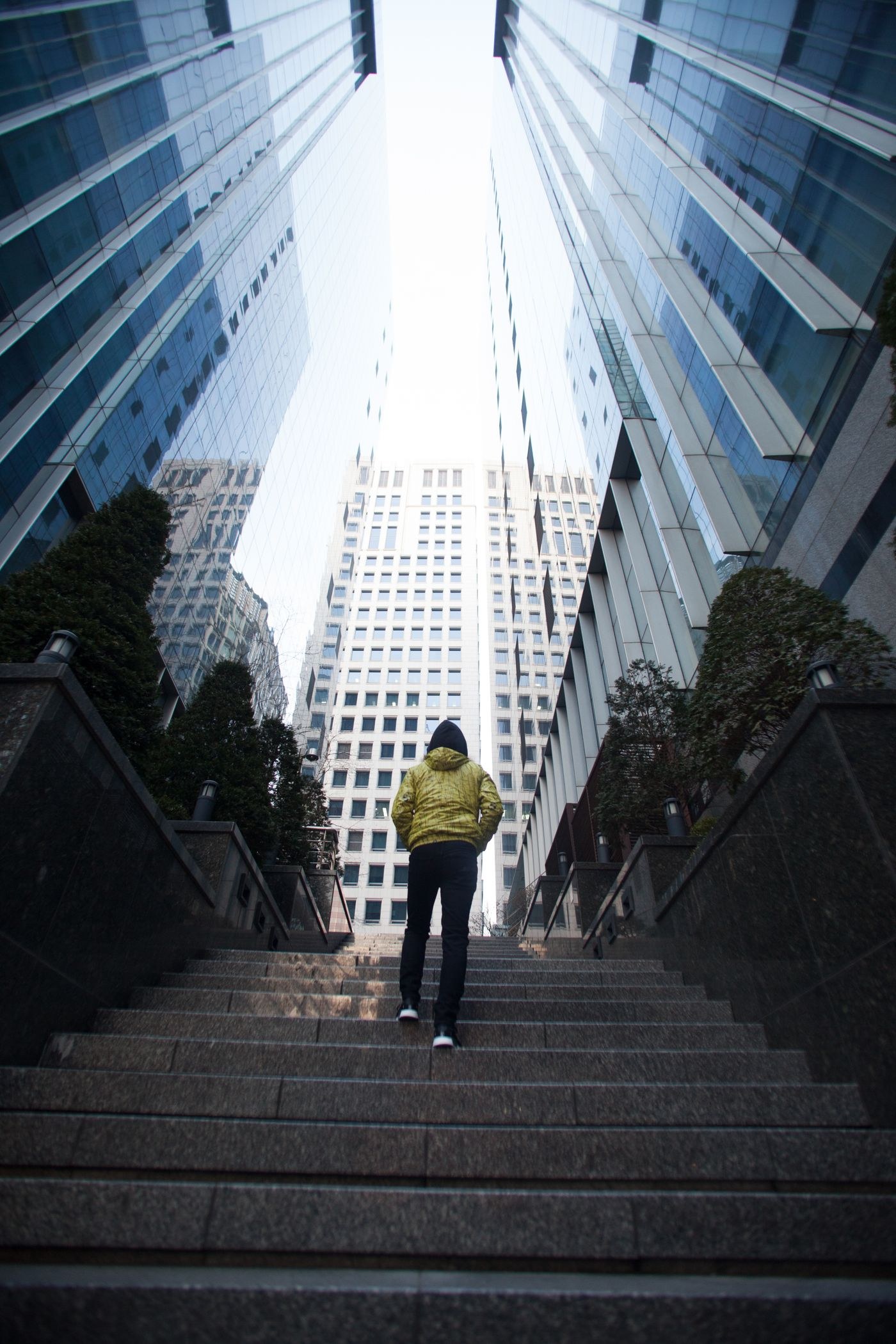 Person ascending steps between tall buildings