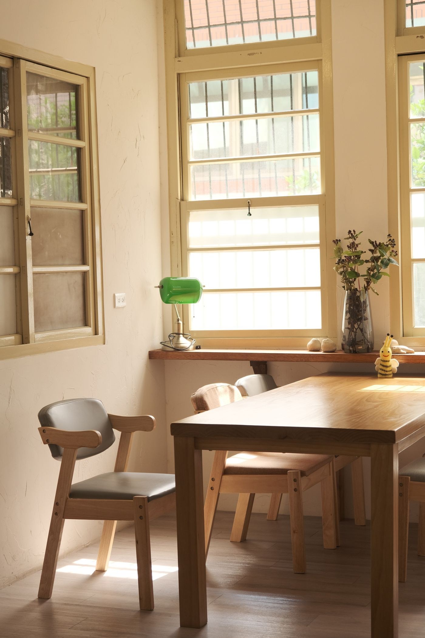 Dining room illuminated through tall bright windows