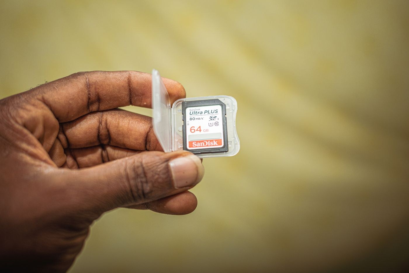 Hand holding a memory card in a protective case