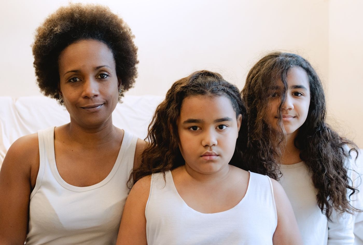 Mother and two daughters in an indoor portrait