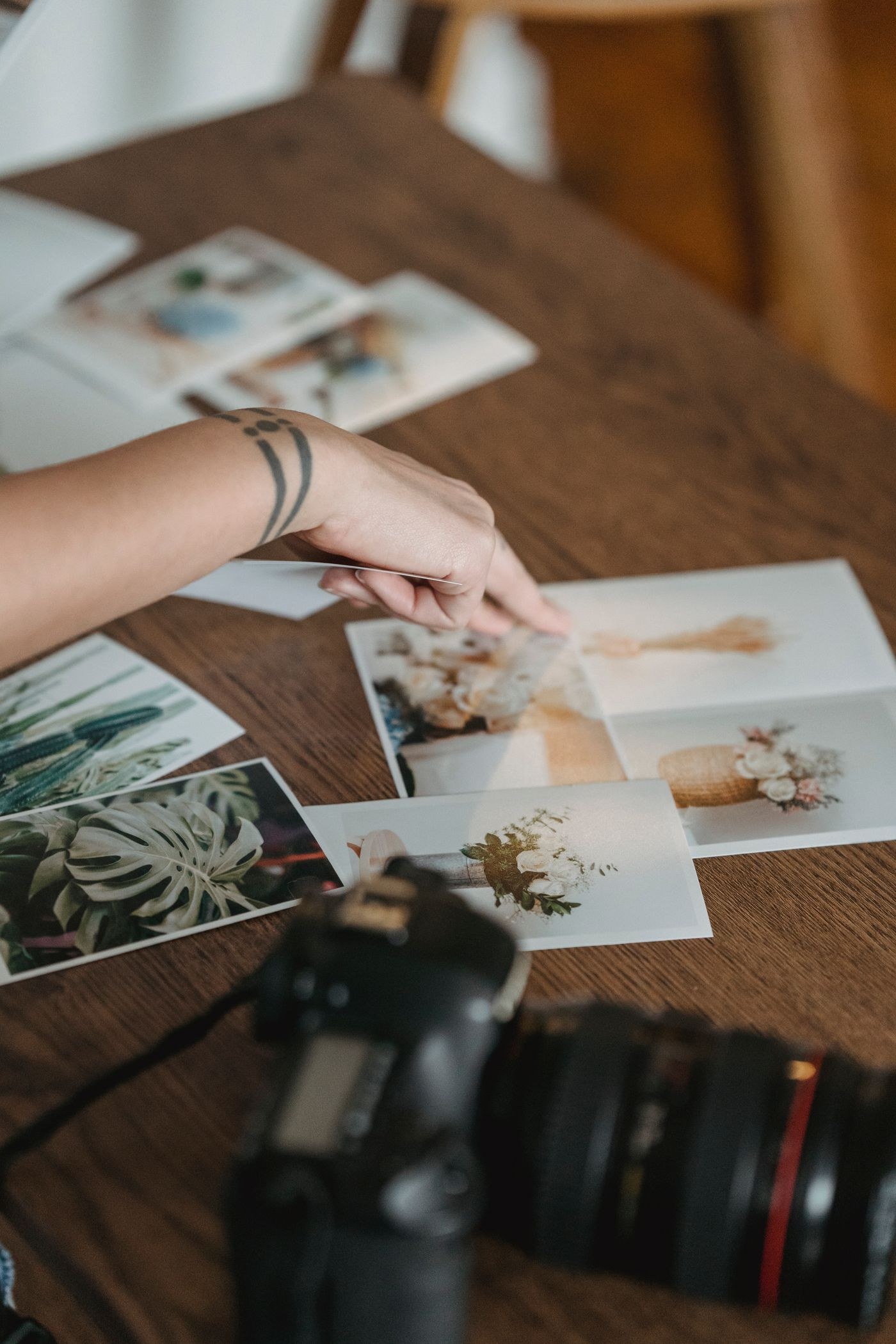 Hands selecting photographic prints on a table